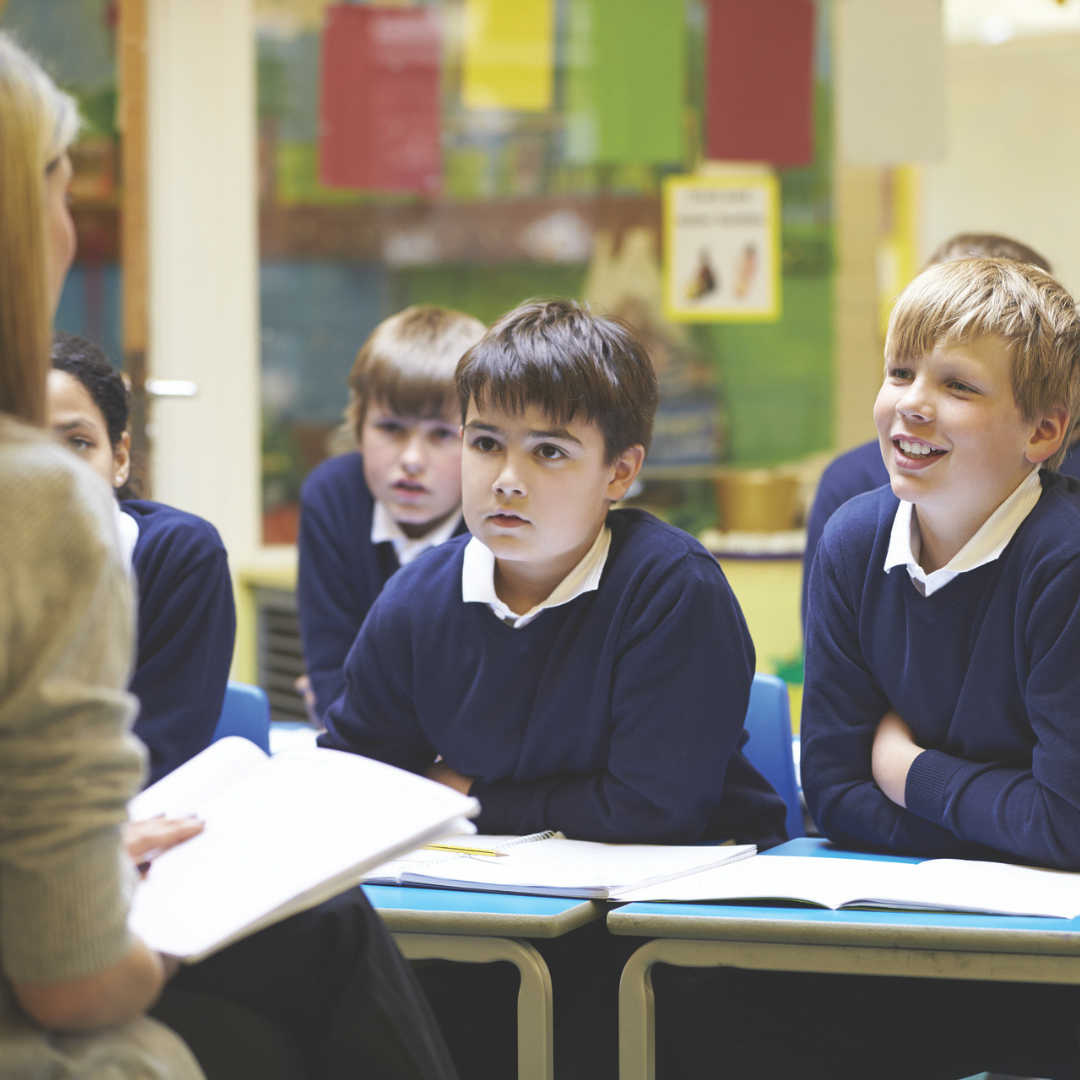 Boy pupils in classroom listening to teacher